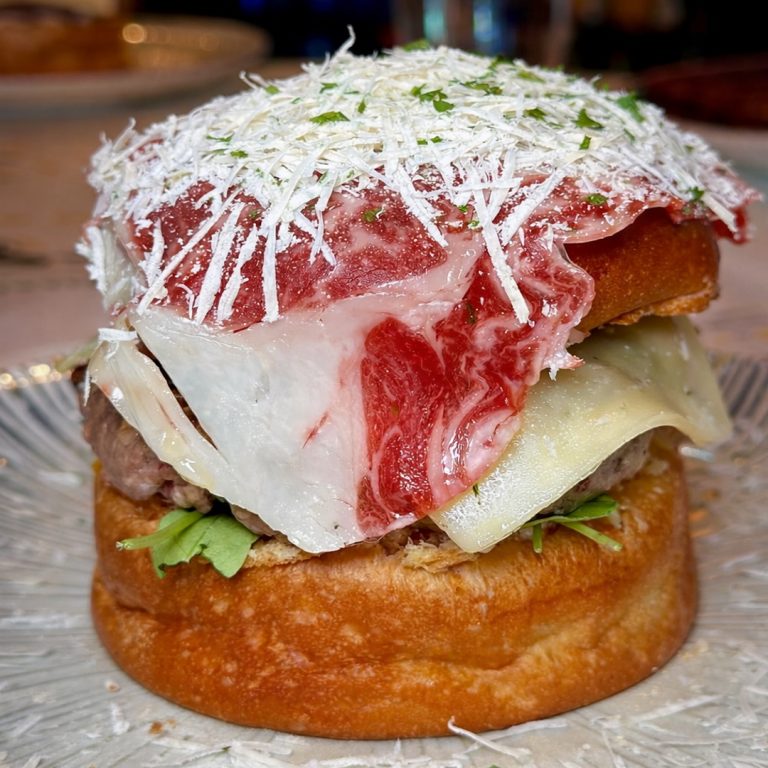 Burger Tolón Tartar con rúcula fresca, yema curada, tartar de naranja a la brasa, queso parmesano, cremoso de tuétano y steak tartar de vaca madurada en Tolón Tolón Bilbao.