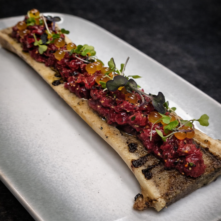 Steak tartar de vaca madurada sobre tuétano a la brasa con yema curada, mostaza antigua y perlas de mango en Tolon Tolon Bilbao