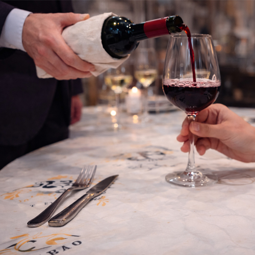 Servicio de sala sirviendo vino en mesa con atención personalizada en Tolón Tolón Bilbao, reflejo del compromiso con la experiencia del cliente.